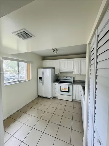 a kitchen with stainless steel appliances kitchen island granite countertop a refrigerator and a stove