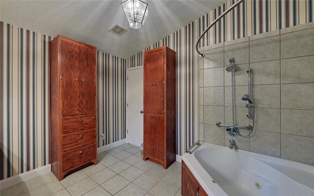 1858 Pinecrest Road Gainesville, GA 30501 - Photo 32 of 55 a bathroom with a bathtub and a shower