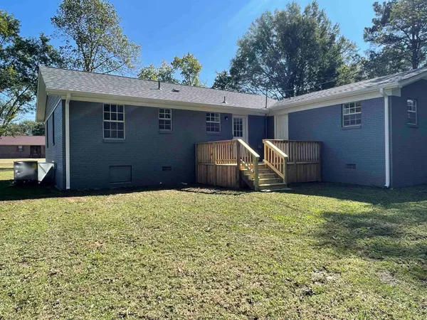 a backyard of house with barbeque oven and brick wall