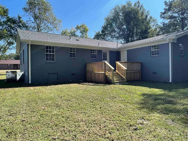 a backyard of house with barbeque oven and brick wall