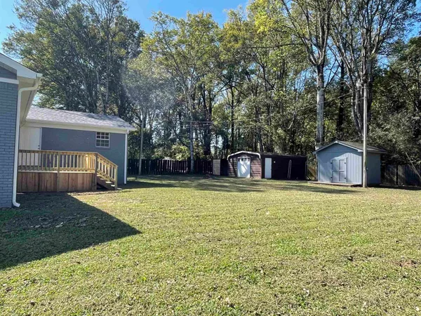 a front view of a house with a yard and trees