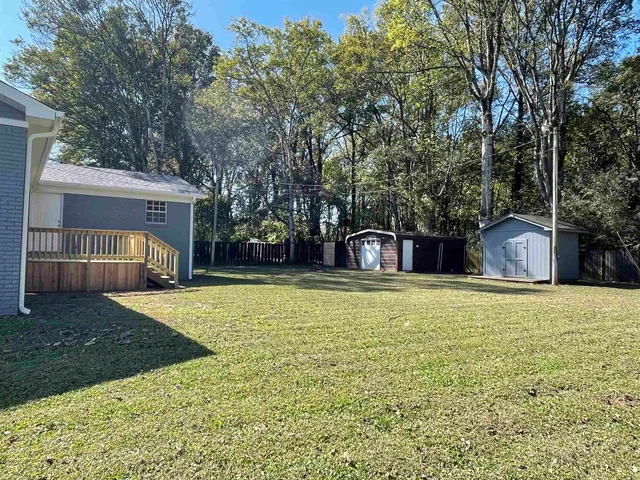 a front view of a house with a yard and trees