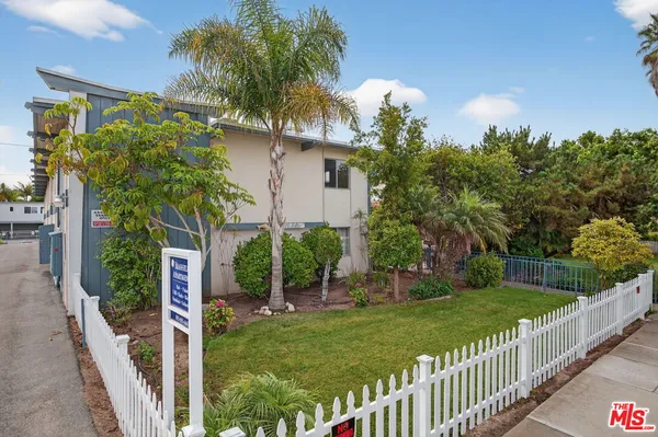 a view of a house with a yard and potted plants