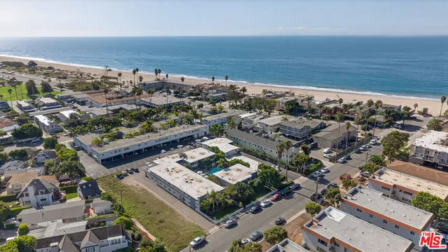 an aerial view of a city with ocean view in back