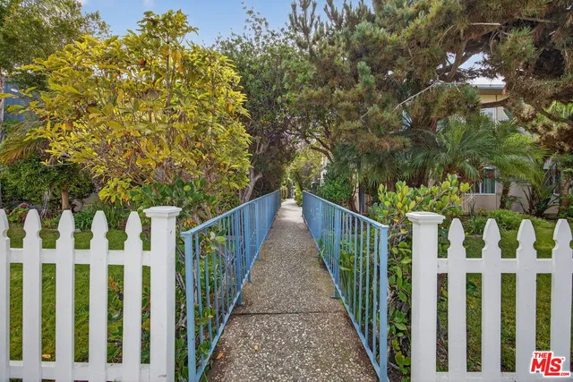 a view of a pathway of a house with wooden fence