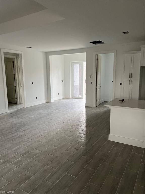 335 Ranch Avenue Lehigh Acres, FL 33974 - Photo 11 of 24 a view of an empty room with wooden floor and cabinet
