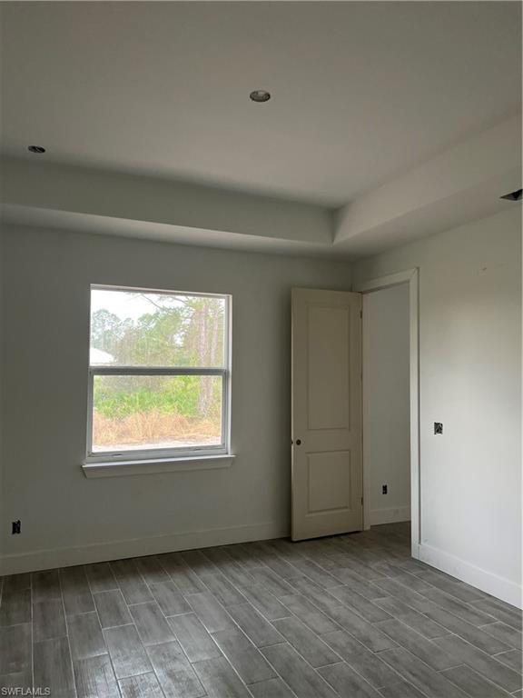 335 Ranch Avenue Lehigh Acres, FL 33974 - Photo 12 of 24 a view of an empty room with wooden floor and a window
