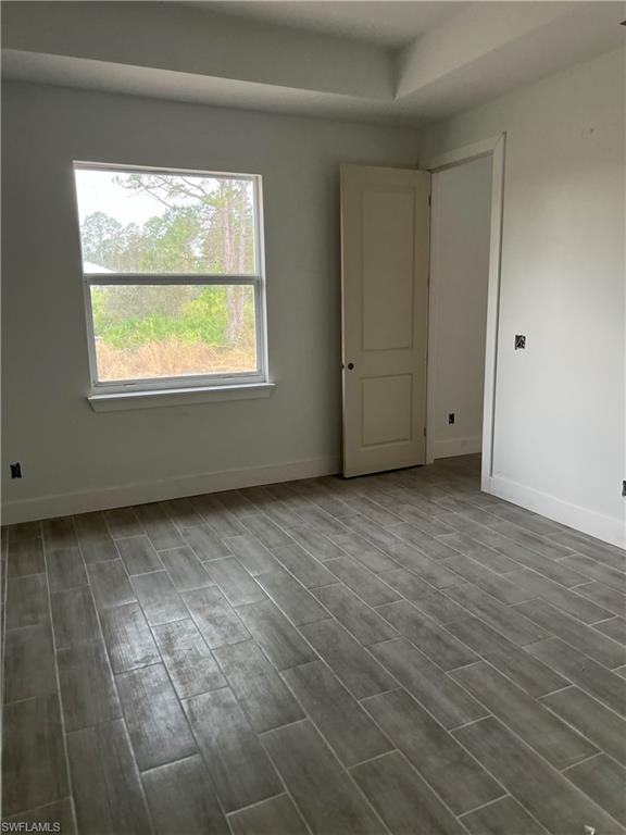 335 Ranch Avenue Lehigh Acres, FL 33974 - Photo 13 of 24 a view of an empty room with wooden floor and a window