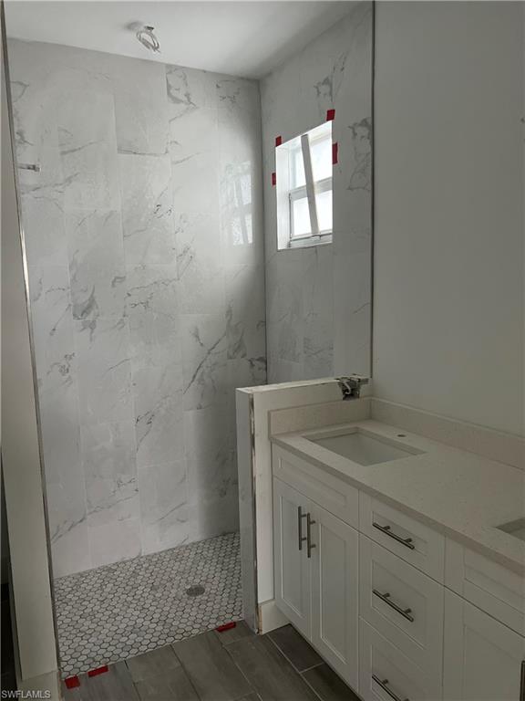 335 Ranch Avenue Lehigh Acres, FL 33974 - Photo 22 of 24 a bathroom with a granite countertop sink a mirror and shower