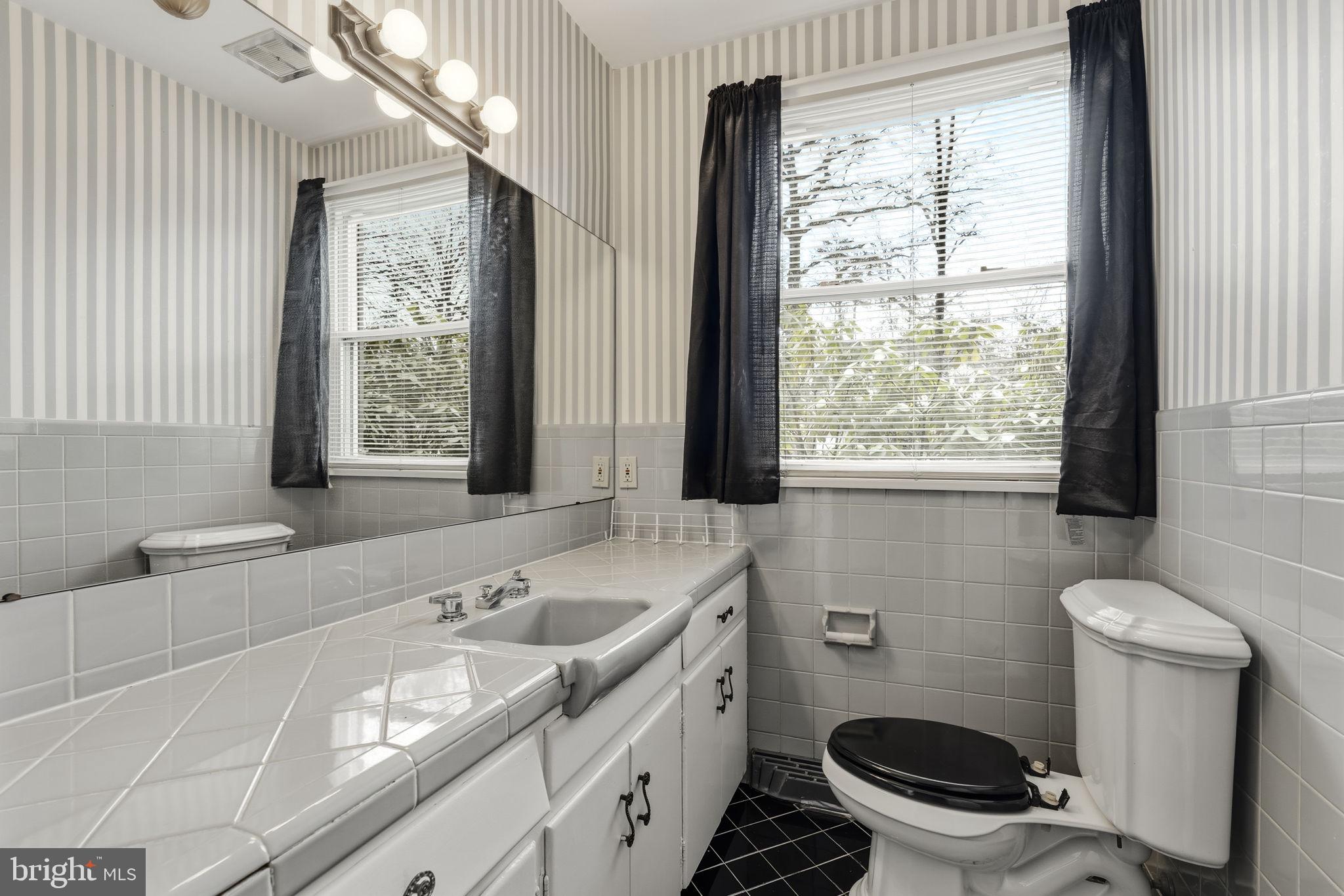 2301 Edgewood Road Harrisburg, PA 17104 - Photo 19 of 63 a bathroom with a granite countertop sink a large mirror a toilet a and window