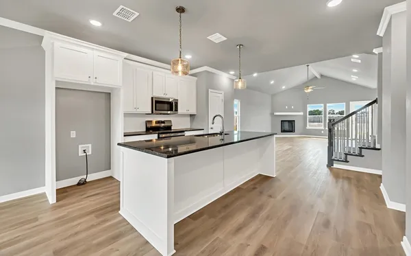 a kitchen with stainless steel appliances kitchen island a refrigerator and a view of living room
