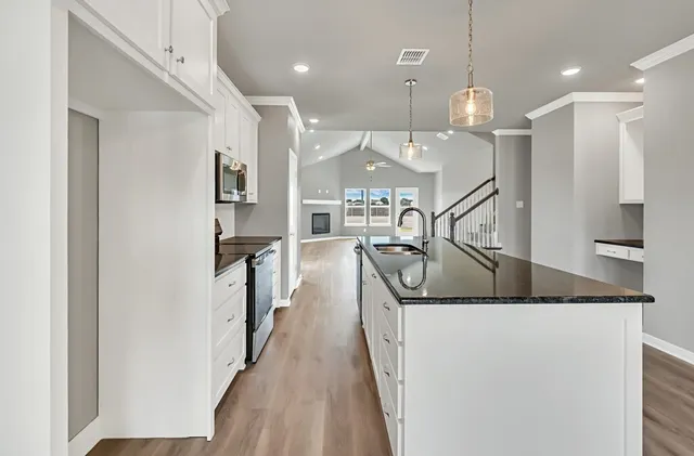 a kitchen with white cabinets and stainless steel appliances