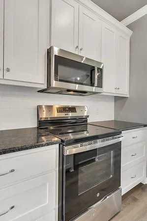 a kitchen with stainless steel appliances granite countertop a sink dishwasher a refrigerator and a stove with wooden floor