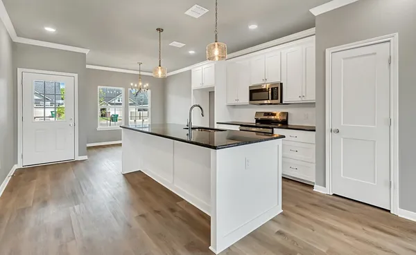 a kitchen with stainless steel appliances granite countertop a sink a stove and a wooden floors