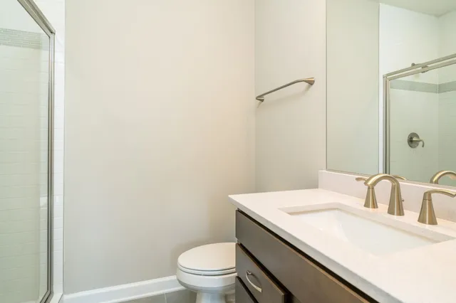 a bathroom with a granite countertop sink toilet and a mirror