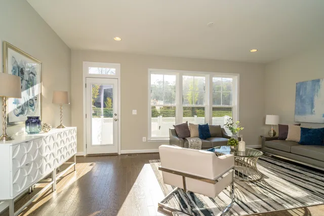 a living room with furniture and a large window with wooden floor