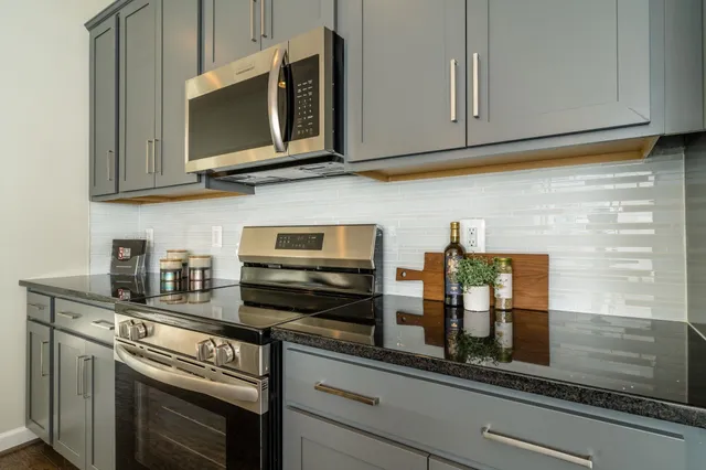 a kitchen with stainless steel appliances granite countertop a stove microwave and cabinets
