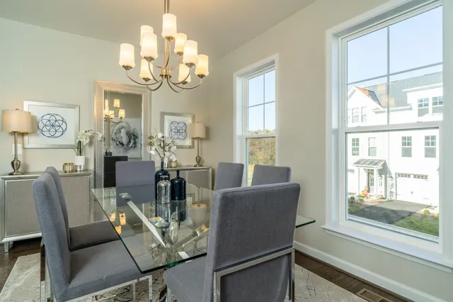 a view of a dining room with furniture a chandelier and a window