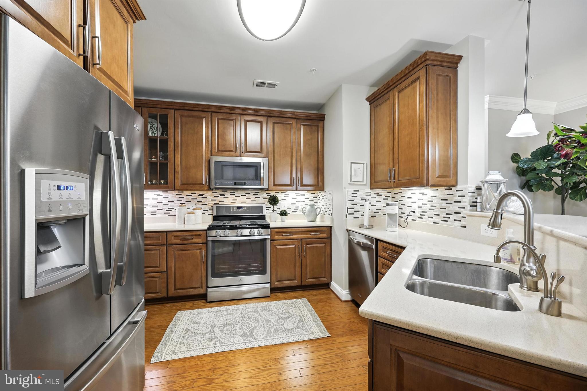 3910 Doc Berlin Drive, Unit 21 Silver Spring, MD 20906 - Photo 13 of 27 a kitchen with granite countertop a sink stainless steel appliances and cabinets
