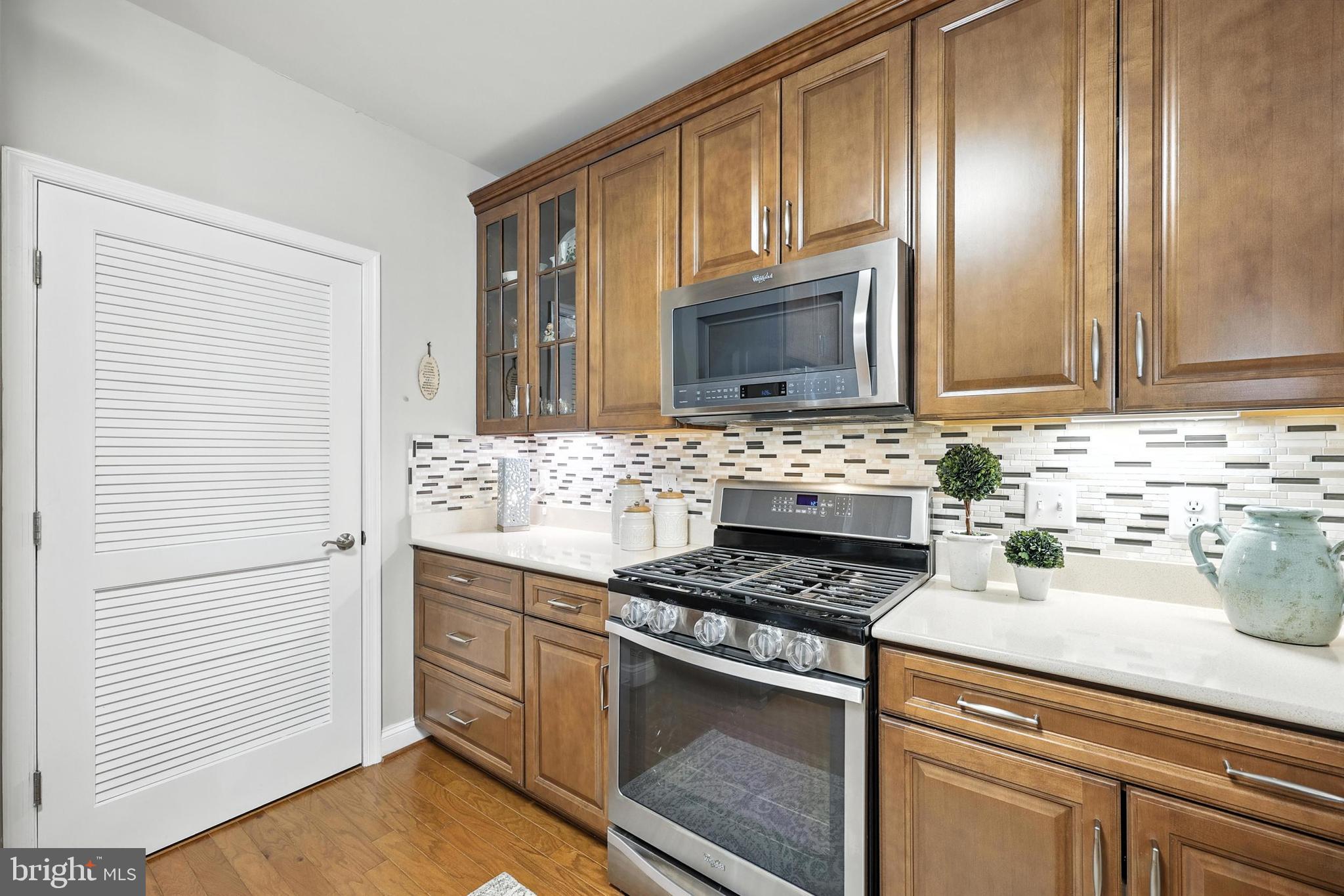 3910 Doc Berlin Drive, Unit 21 Silver Spring, MD 20906 - Photo 16 of 27 a kitchen with granite countertop cabinets stainless steel appliances and wooden floor