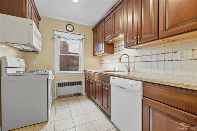 a kitchen with stainless steel appliances granite countertop a sink and dishwasher a stove with wooden cabinets