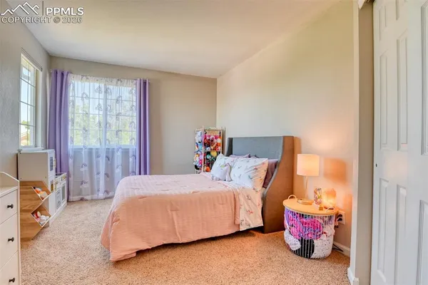 a bedroom with a bed closet and a window