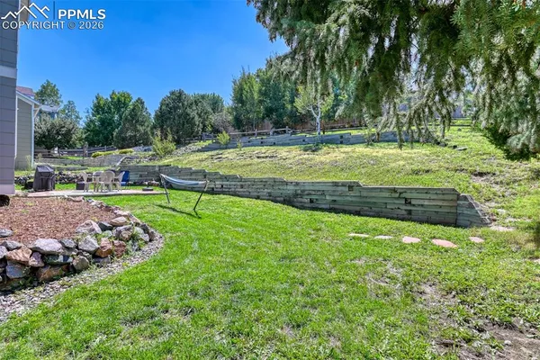 a front view of a house with a garden and trees