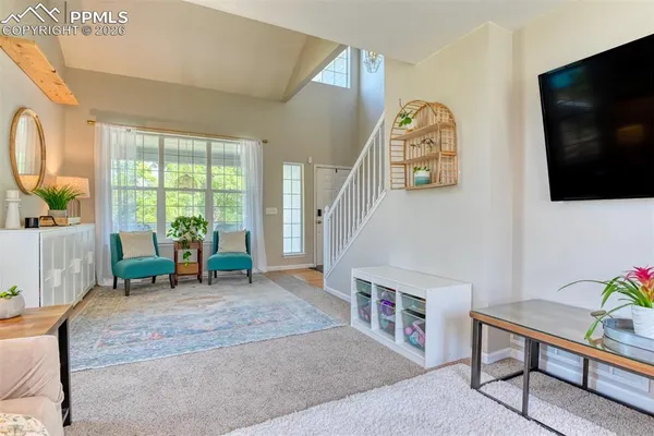 a living room with furniture a window and a mirror