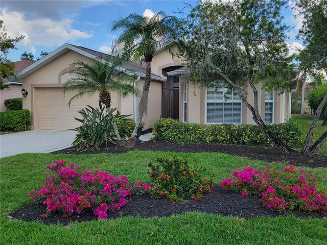 a front view of a house with a big yard and potted plants
