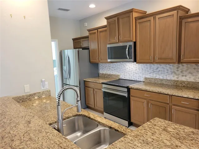 a view of a hallway with wooden floor and a living room