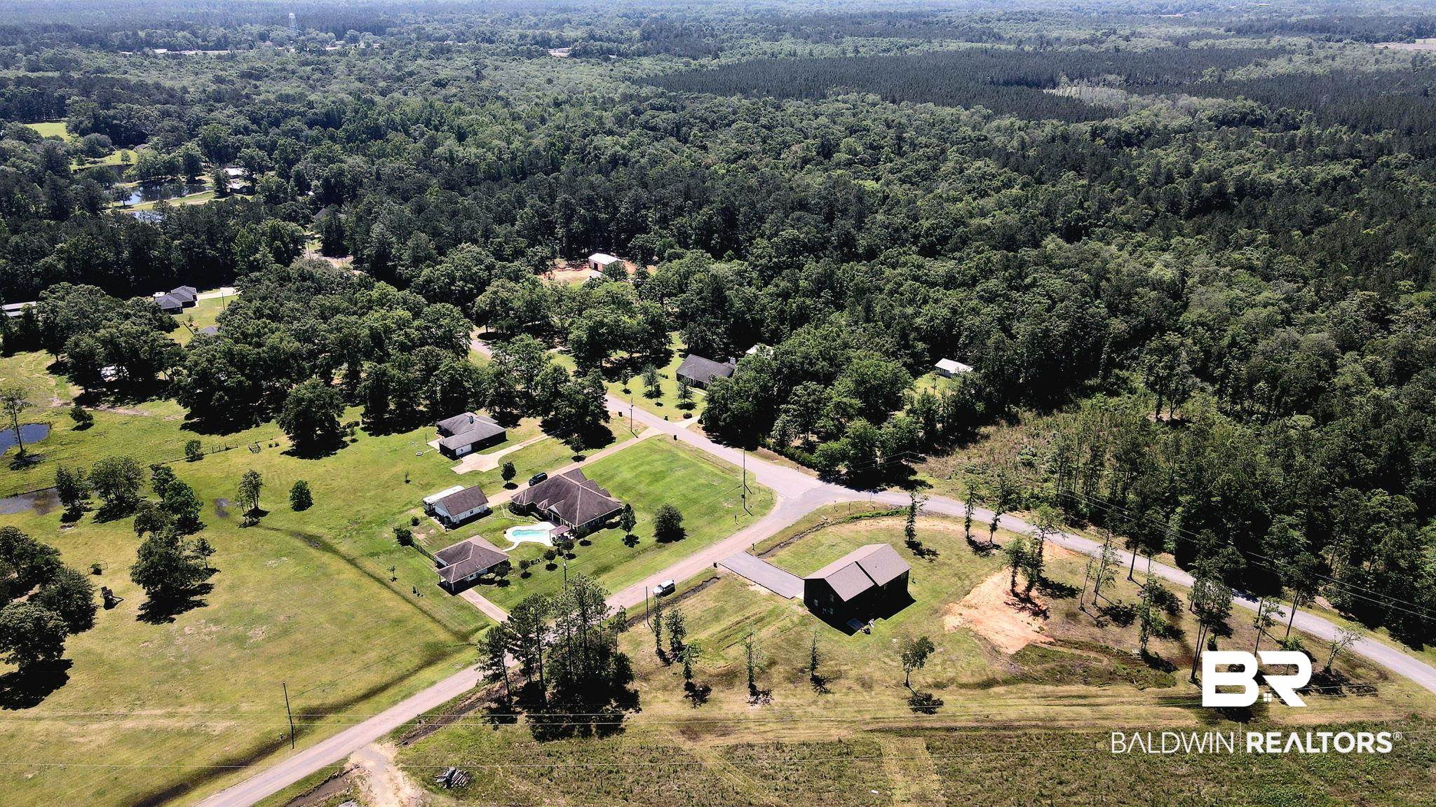 11025 Creax Road Axis, AL 36505 - Photo 42 of 45 Aerial perspective showcasing a residential property with a central home, an in-ground swimming pool, and multiple outbuildings