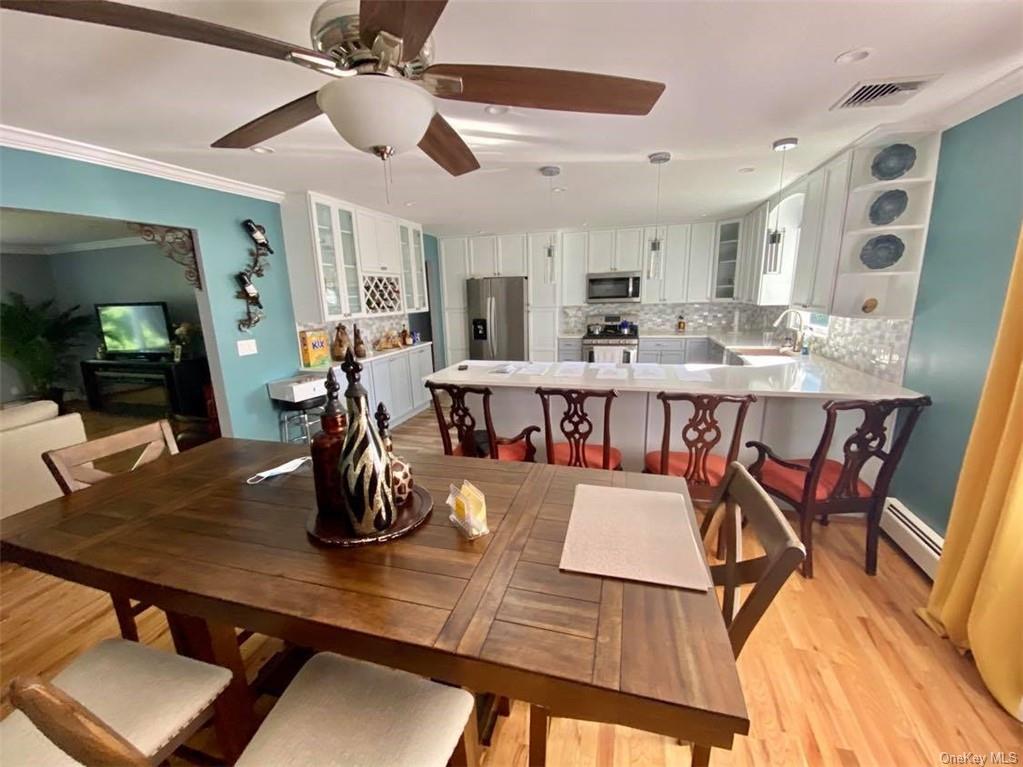 a room with stainless steel appliances dining table and chairs