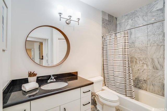 a bathroom with a sink a toilet and a mirror