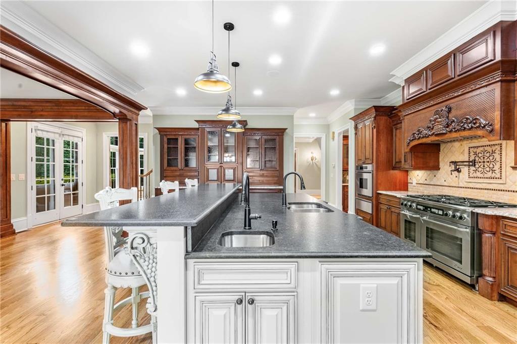 16050 South Thompson Road Milton, GA 30004 - Photo 31 of 72 a kitchen with stainless steel appliances granite countertop a sink a stove and a wooden floors