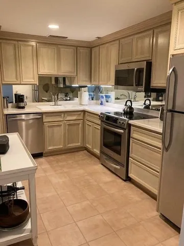 a kitchen with a sink stainless steel appliances and cabinets