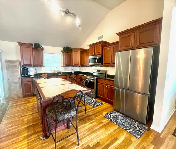 a kitchen with stainless steel appliances a refrigerator a stove a sink dishwasher and a refrigerator