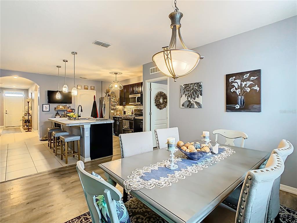 1765 Brockridge Road Kissimmee, FL 34744 - Photo 12 of 45 a open dining room with furniture a chandelier and wooden floor