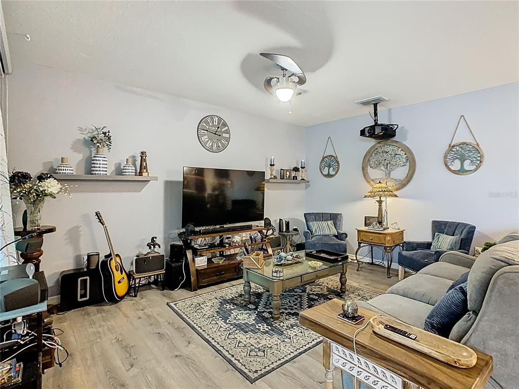 1765 Brockridge Road Kissimmee, FL 34744 - Photo 15 of 45 a living room with furniture a clock and a flat screen tv