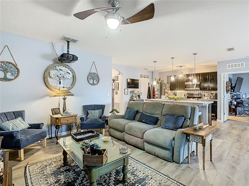 1765 Brockridge Road Kissimmee, FL 34744 - Photo 16 of 45 a living room with furniture kitchen view and a chandelier