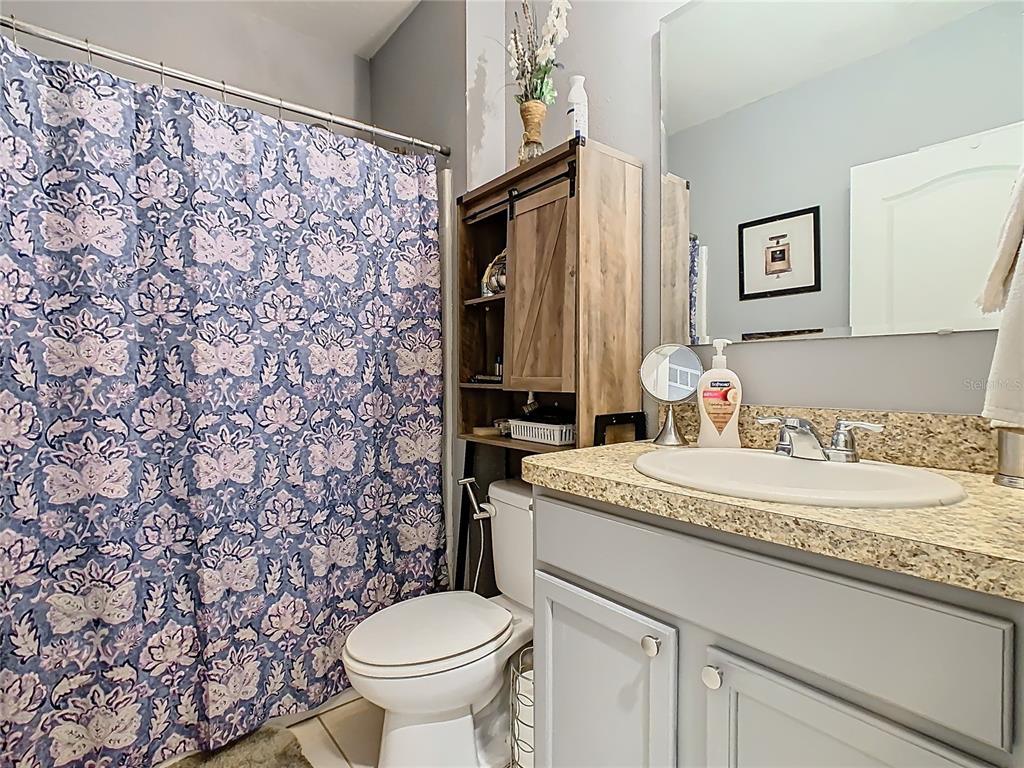 1765 Brockridge Road Kissimmee, FL 34744 - Photo 22 of 45 a bathroom with a granite countertop sink and a toilet