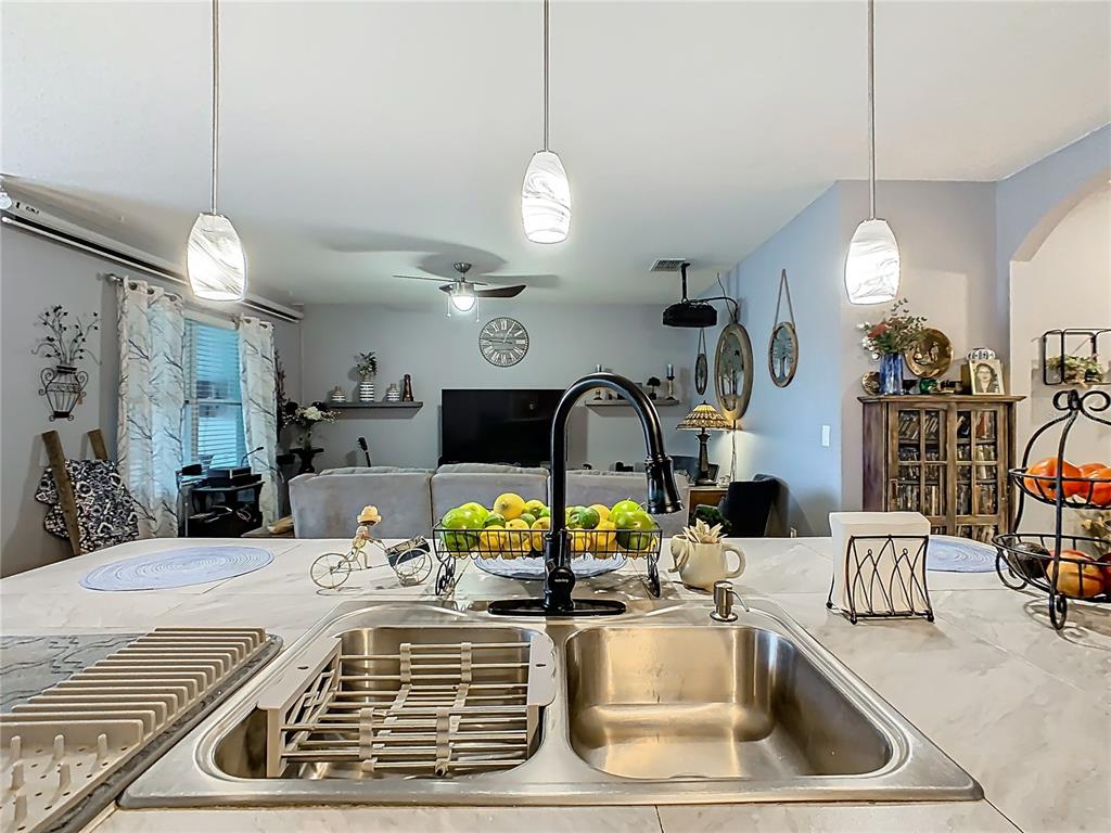 1765 Brockridge Road Kissimmee, FL 34744 - Photo 7 of 45 a kitchen with a sink a counter and chairs