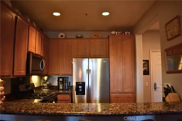 a kitchen with stainless steel appliances granite countertop a refrigerator and a sink
