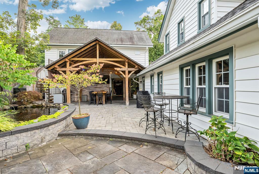 203 Long Pond Road West Milford, NJ 07421 - Photo 39 of 50 a view of a patio with table and chairs potted plants and floor to ceiling window