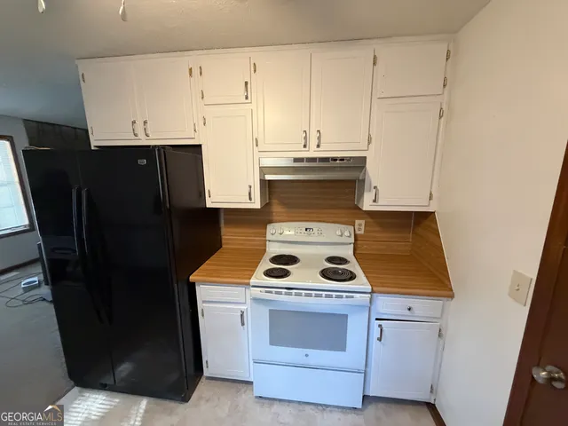 a stove top oven sitting inside of a kitchen