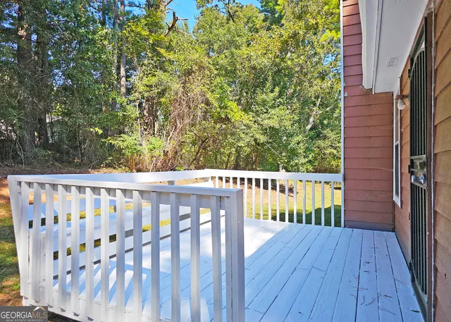 a view of a balcony with wooden floor and fence
