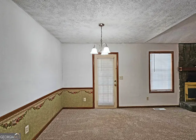 an empty room with chandelier fan