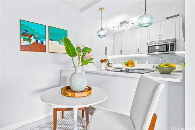 a dining room with stainless steel appliances a table chairs and chandelier