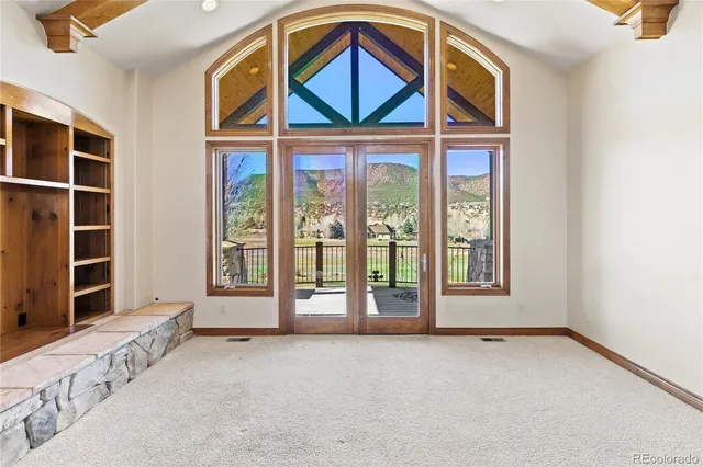 a view of an empty room with a fireplace and a window