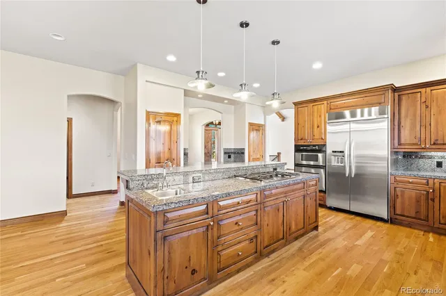 a kitchen with stainless steel appliances granite countertop a stove a sink dishwasher and a refrigerator