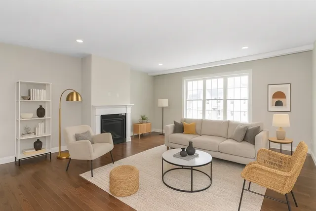 a living room with furniture a fireplace and a large window